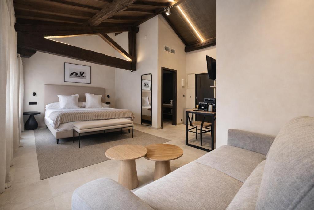a bedroom with a bed and a couch and a table at Hotel El Paraíso del Pas in Barcenilla