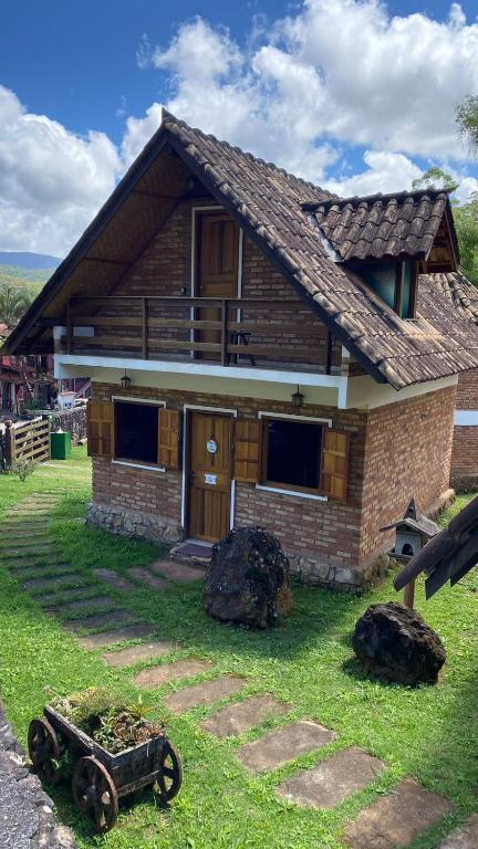 a wooden house with a wagon in front of it at Chalé Ouro in Ouro Preto