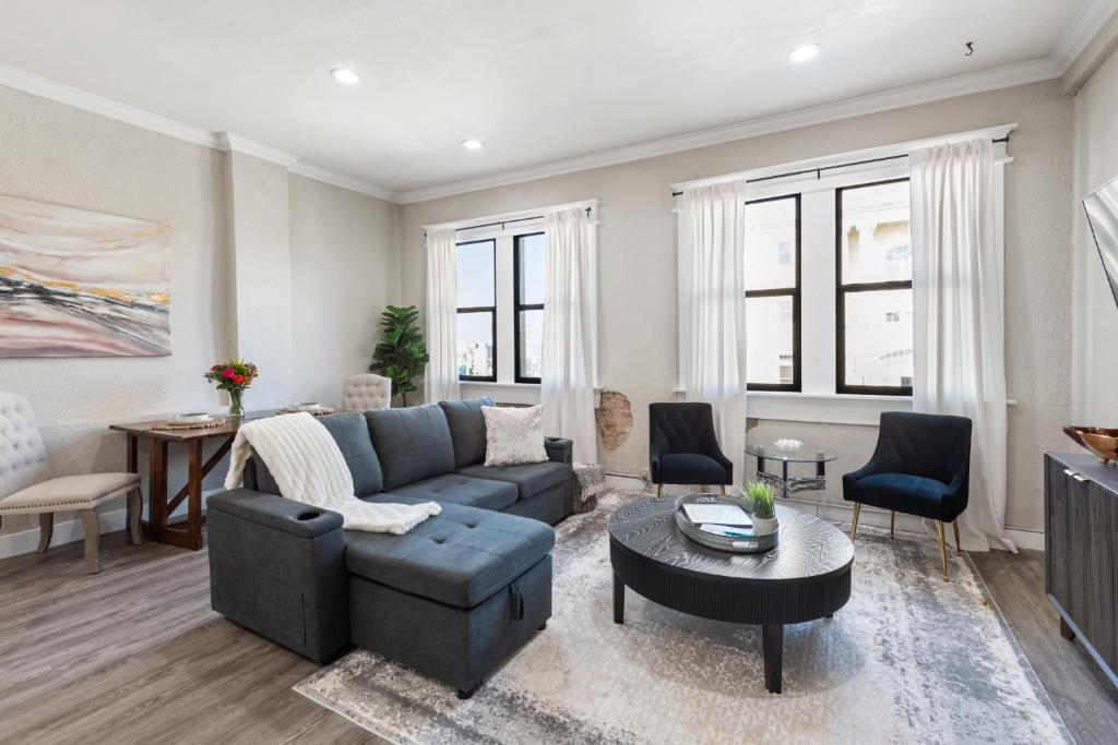 a living room with a couch and a table at Stunning Apartment w Panoramic Downtown Views! in McKinney