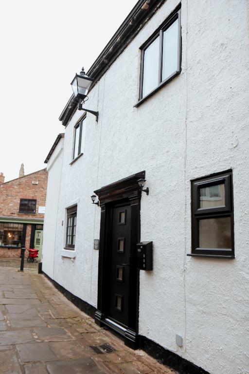 a white building with a black door and windows at Britannia Lodge in Howden