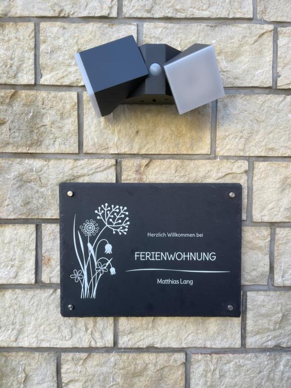 a sign on the side of a brick wall at Ferienwohnung Matthias Lang in Rugendorf