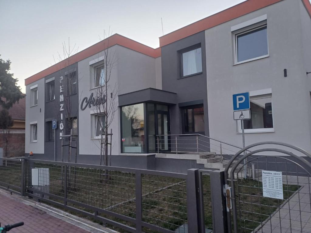 a white building with a parking meter in front of it at Apartmány ARIES in Nitra