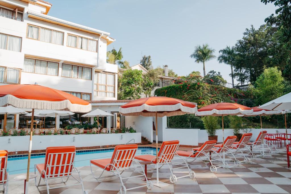 a group of chairs and umbrellas next to a pool at Céline & Lolo in Nairobi