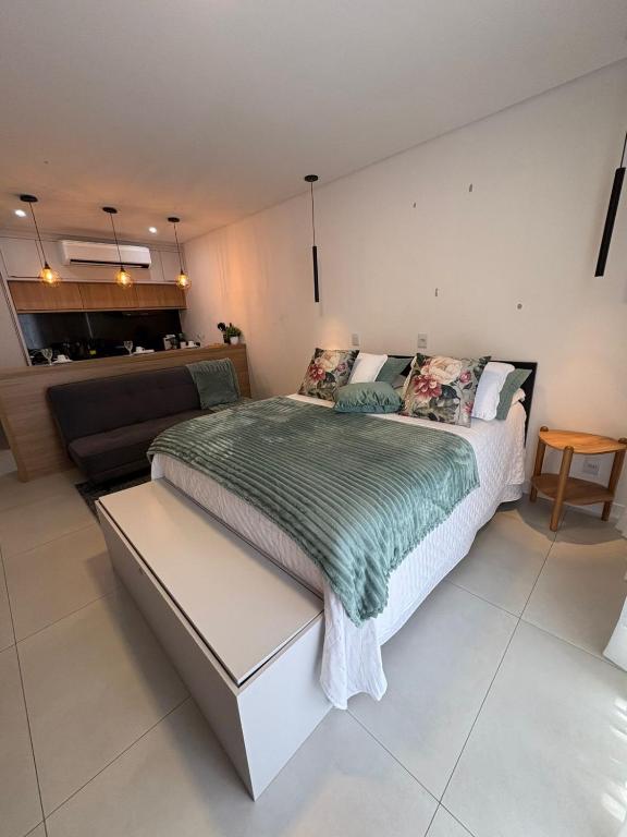 a bedroom with a large bed and a couch at Apartamento Dein Haus in Pomerode