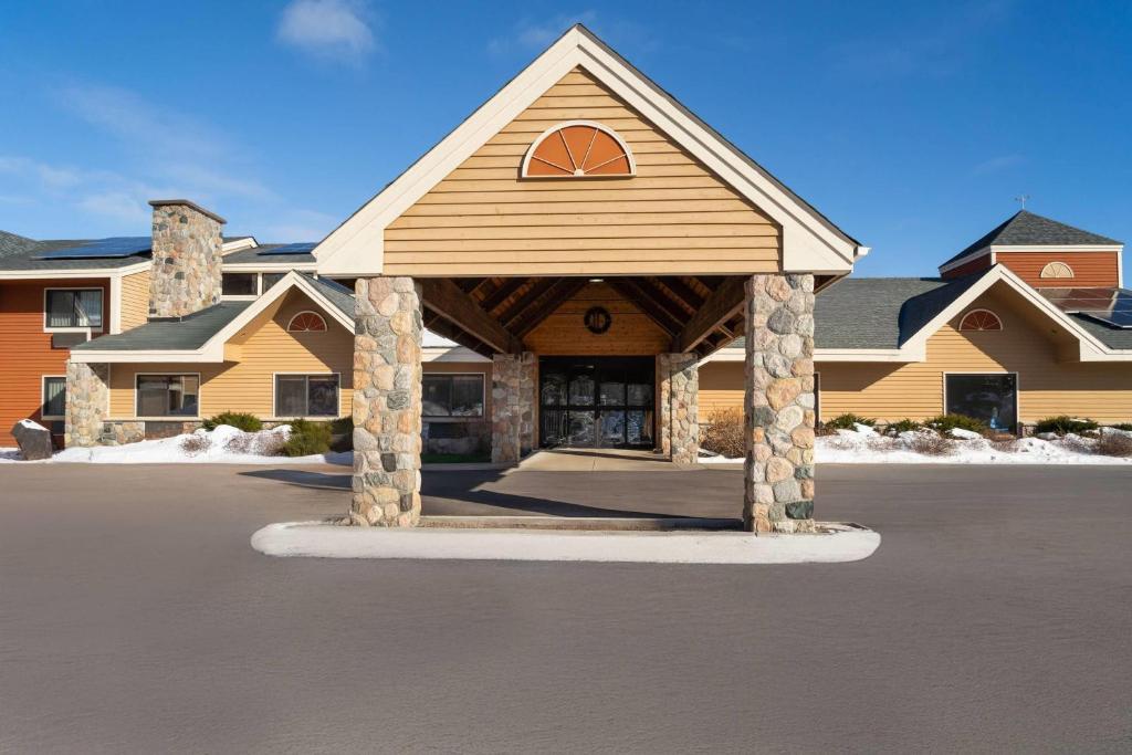 a large building with a porch in a parking lot at AmericInn by Wyndham Tofte Near Lake Superior in Tofte