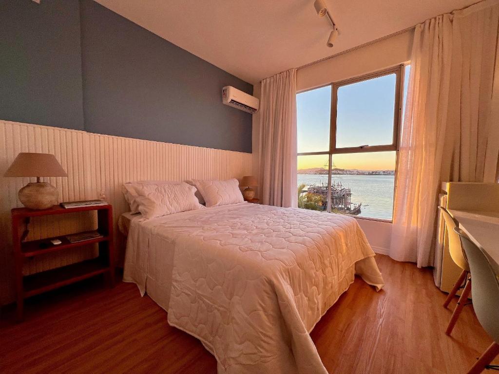 a bedroom with a bed and a large window at Casa Veleiro in Florianópolis