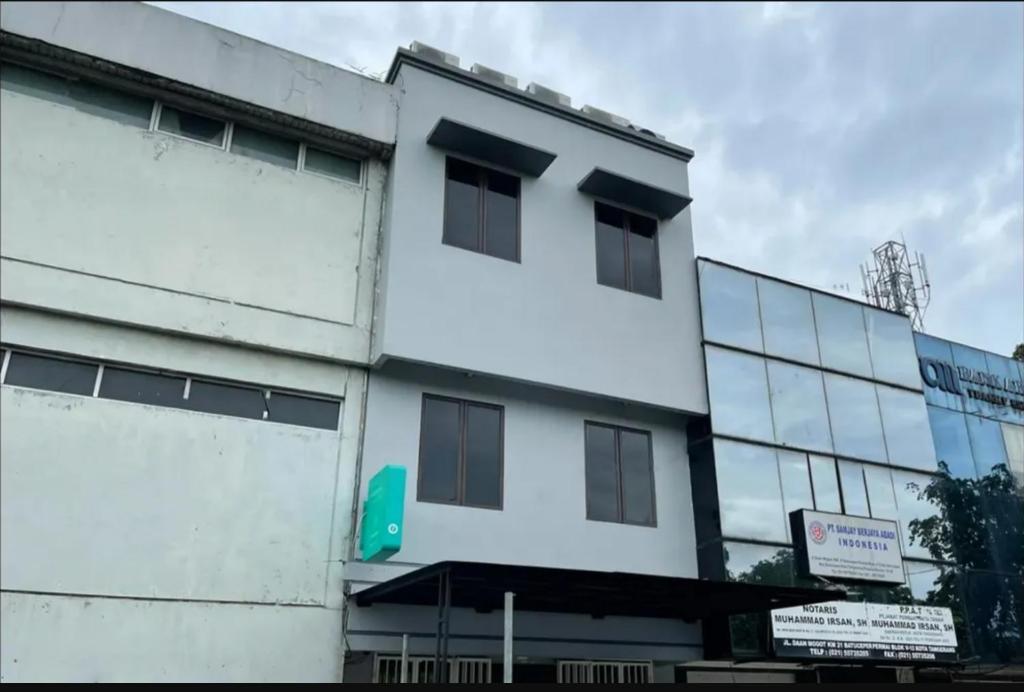 a white building with a sign in front of it at Mutiara Kostel at Batuceper in Poris-lor