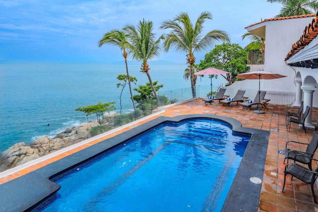 a swimming pool with a view of the ocean at Ocean Front Villa - Private Pool and Ocean Access in Puerto Vallarta