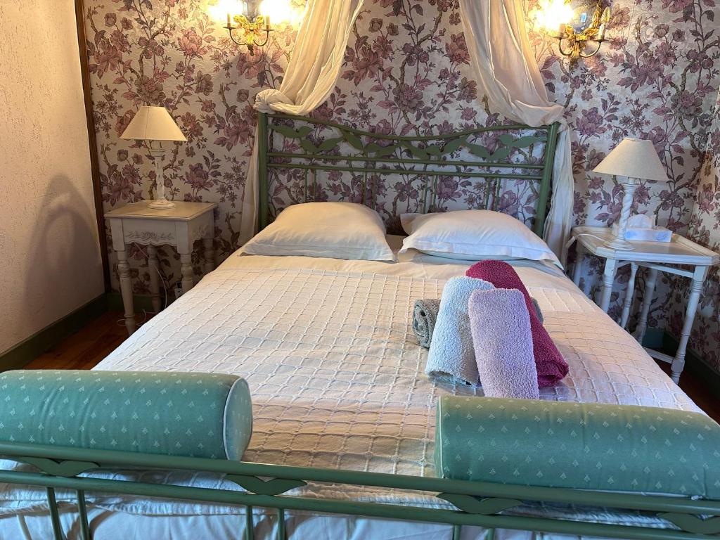 a bedroom with a bed with two pillows and two tables at Chambre dans un Moulin in Rouy