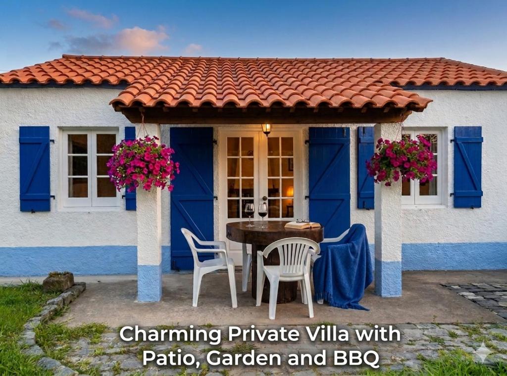 a blue and white house with a table and chairs at Prédio do Castelo in Caloura