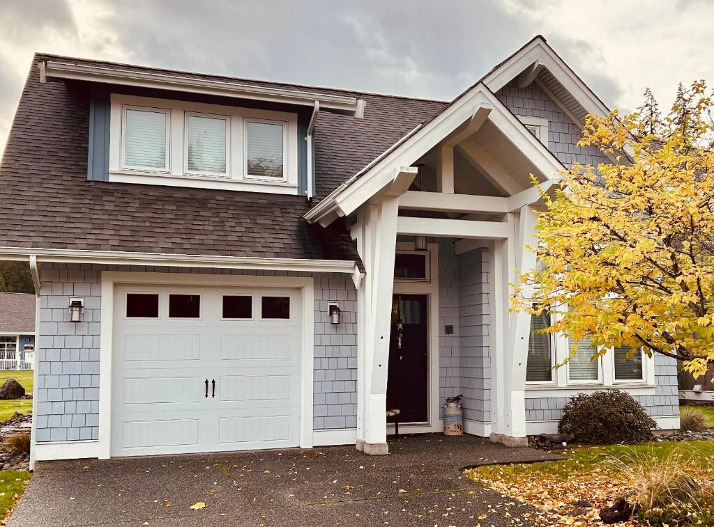 a house with a white garage door at Qualicum Landing West Coast Cottage in Qualicum Beach