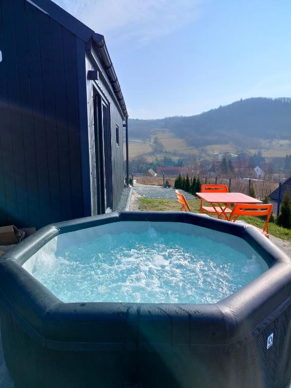 a large hot tub on a patio with a table at Domek Pośród Gór - JACUZZI WLICZONE W CENIE POBYTU,bajeczne widoki, relax i spokój in Laski