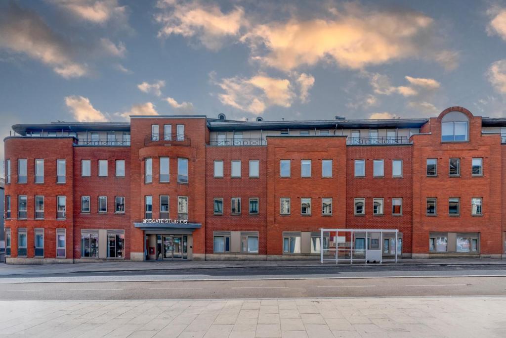 a large red brick building on a city street at Stylish & Spacious Studio - Prime Briggate Location -Walk Everywhere in Leeds
