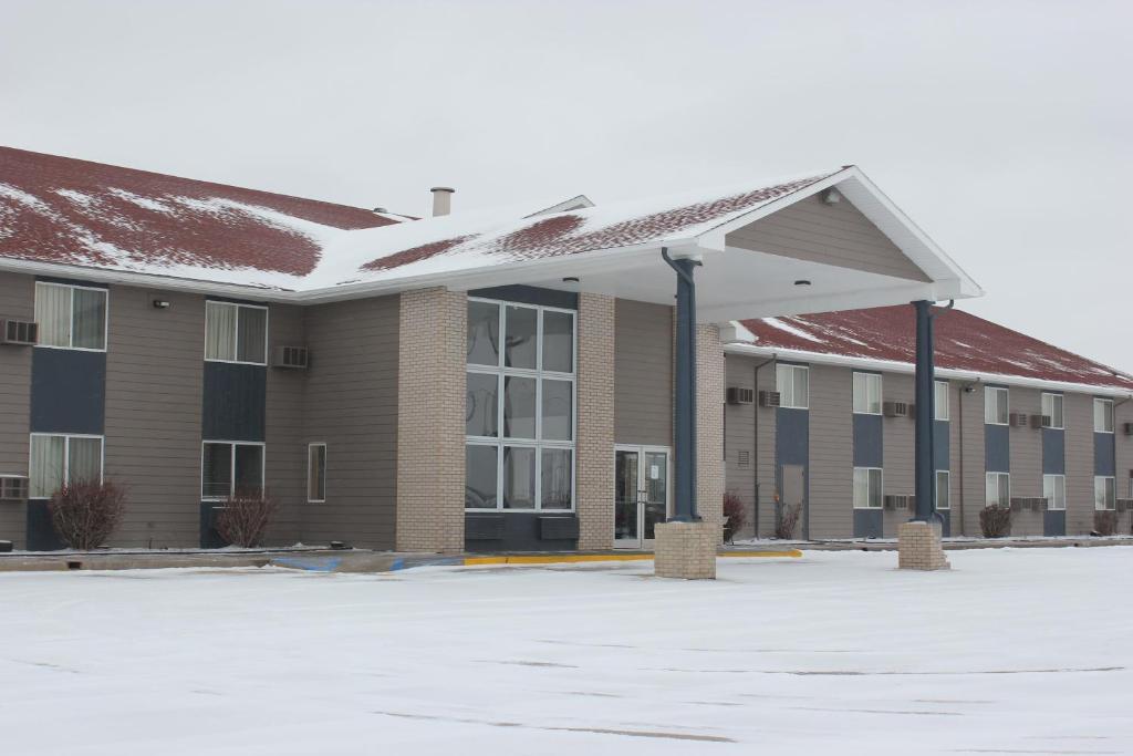 an empty parking lot in front of a building at Alliance Hotel & Suites, a Howard Johnson by Wyndham in Alliance
