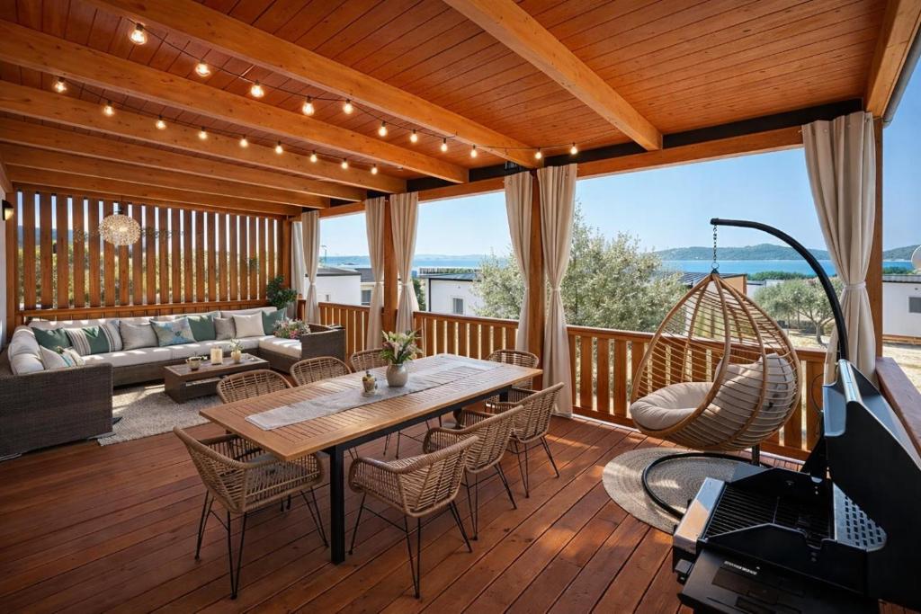 a patio with a table and chairs on a deck at Rose Diamond Villa - cosy, large, family mobile home, free wifi and parking in Pakoštane