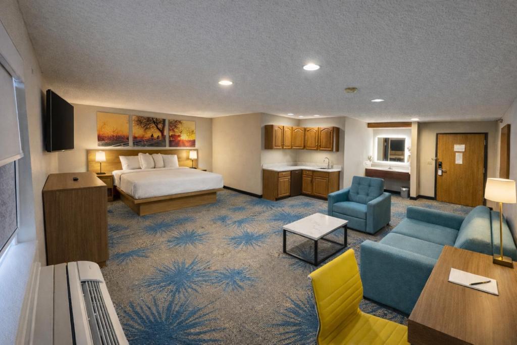 a hotel room with a bed and a living room at Days Inn by Wyndham Sturgis SOUTHDAKOTA in Sturgis
