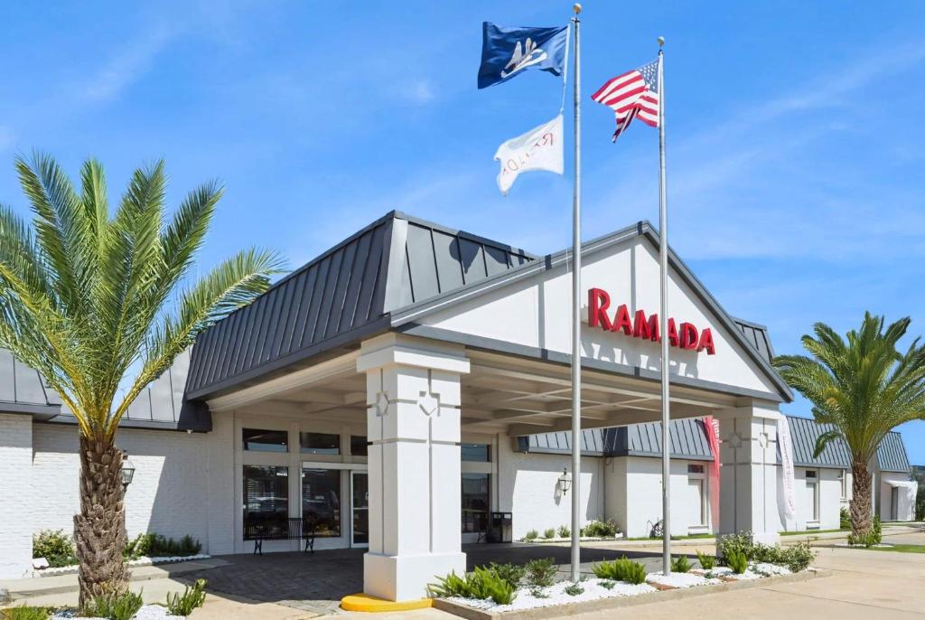 a restaurant with two flags in front of a building at Ramada by Wyndham Houma in Houma