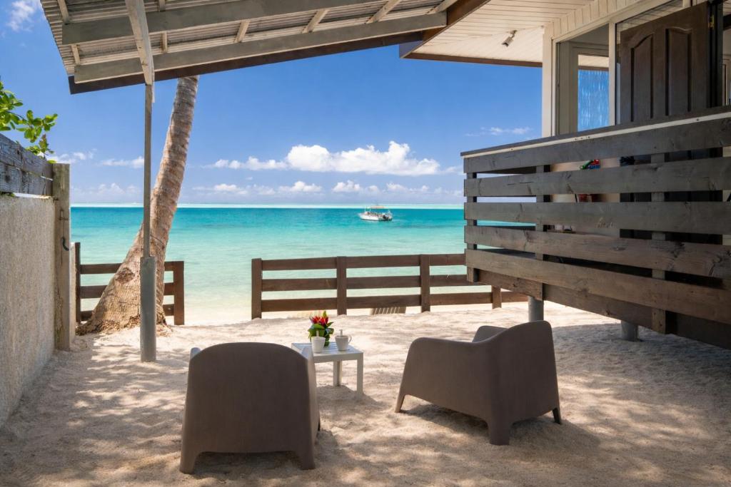 plaża z dwoma krzesłami i stołem oraz oceanem w obiekcie Matira Lagoon w mieście Bora Bora