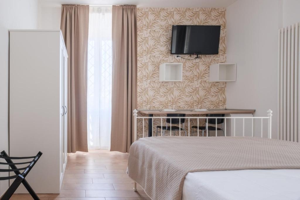 a bedroom with a bed and a tv on a wall at Rooms 2Binari in Bologna