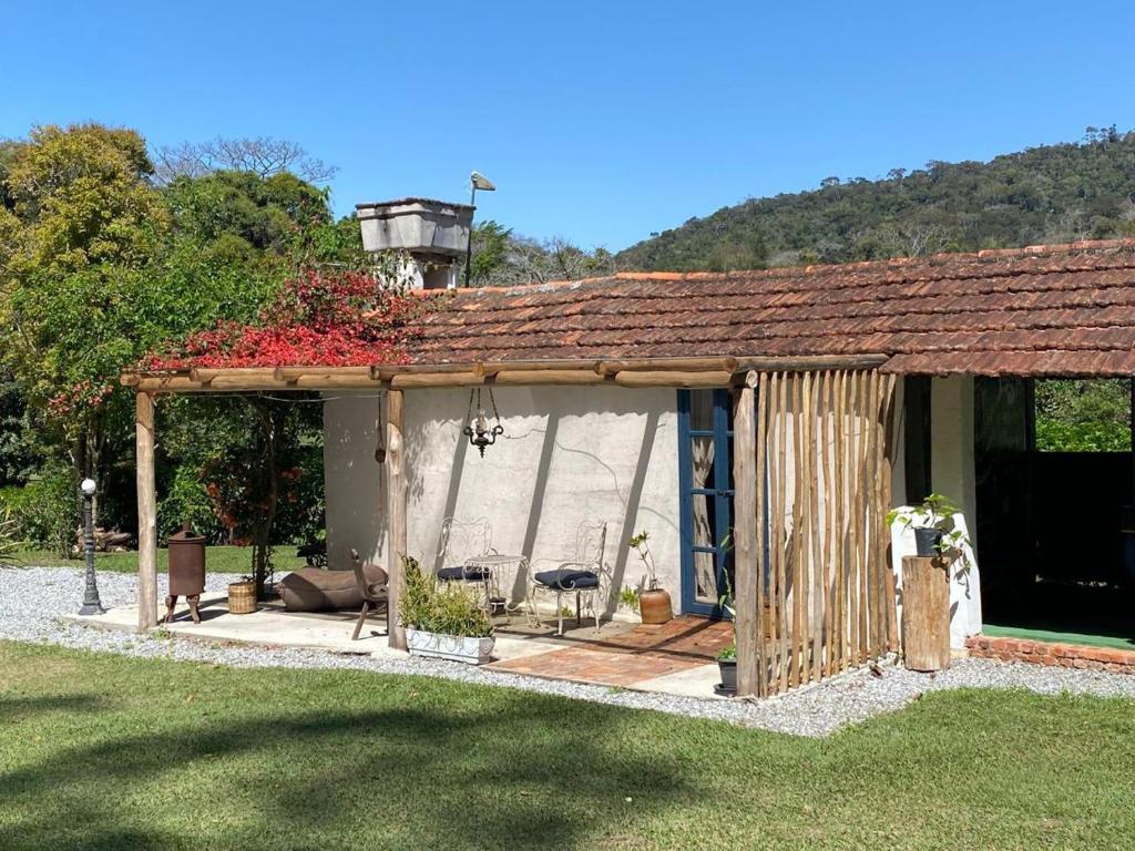 a pavilion with a table and chairs in a yard at Bocaina Sítio da Vovó in Engenheiro Paulo de Frontin