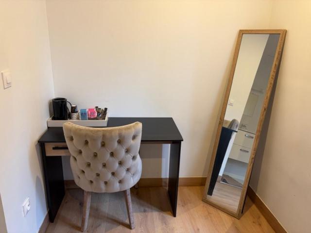 a desk with a chair next to a mirror at Hôtel Le Normandie in Le Mans