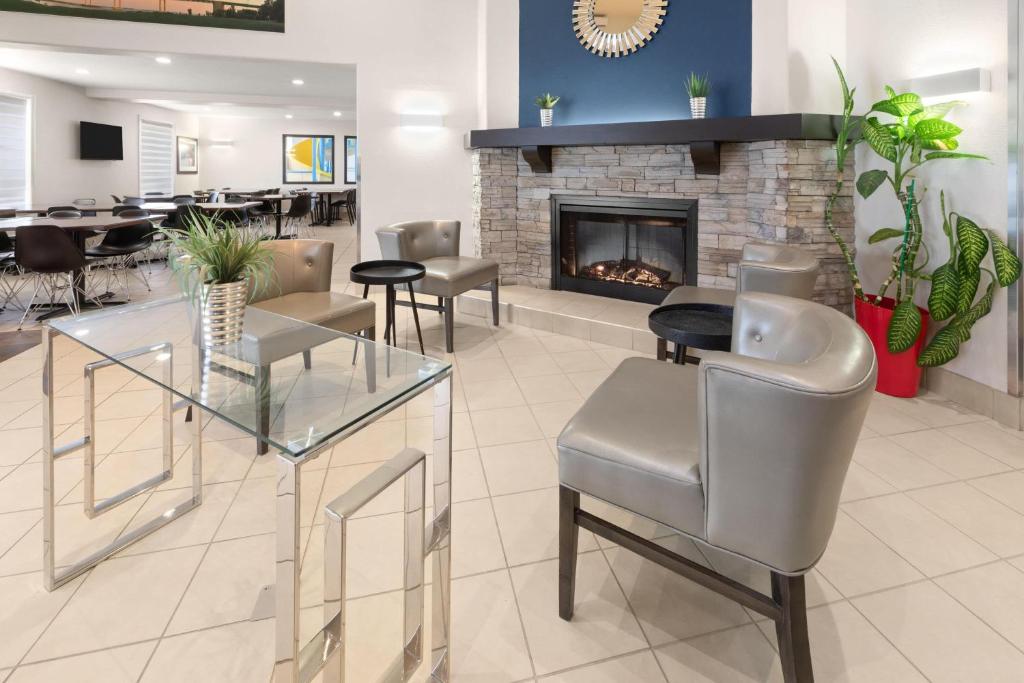 a lobby with a fireplace and tables and chairs at Super 8 by Wyndham Trois-Rivieres in Trois-Rivières