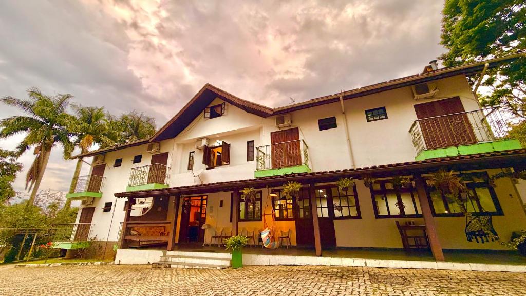 a large white building with windows and balconies at Ninho dos Passaros Penedo RJ in Penedo