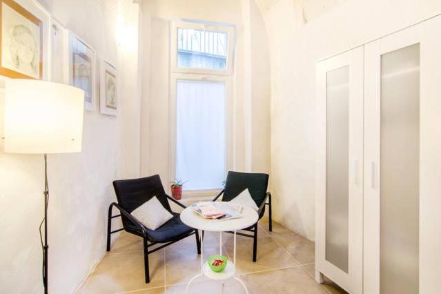 Habitación con 2 sillas, mesa y ventana en Dimora nei Sassi, en Matera