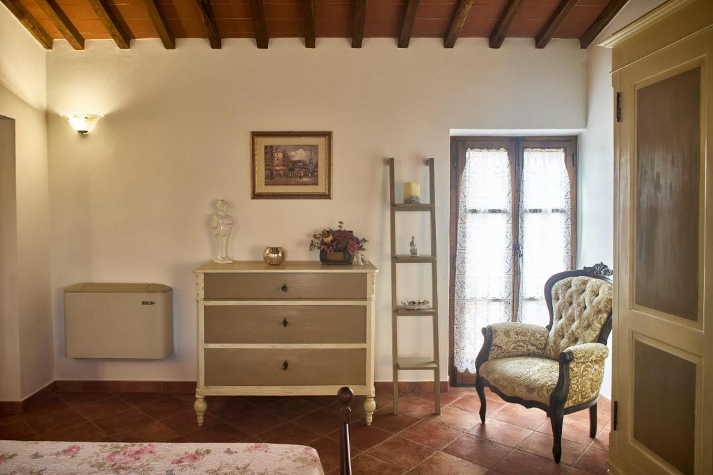 a bedroom with a dresser and a chair and a window at Podere il Granaio - Crete Senesi - Tuscany in Siena