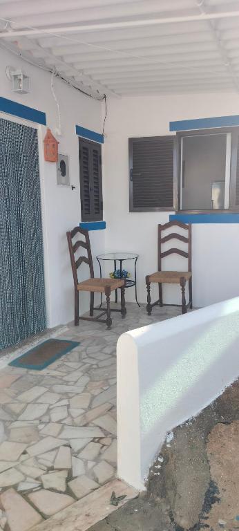 a patio with two chairs and a table in a building at Casa dos Avós Palma - Alcoutim in Alcoutim