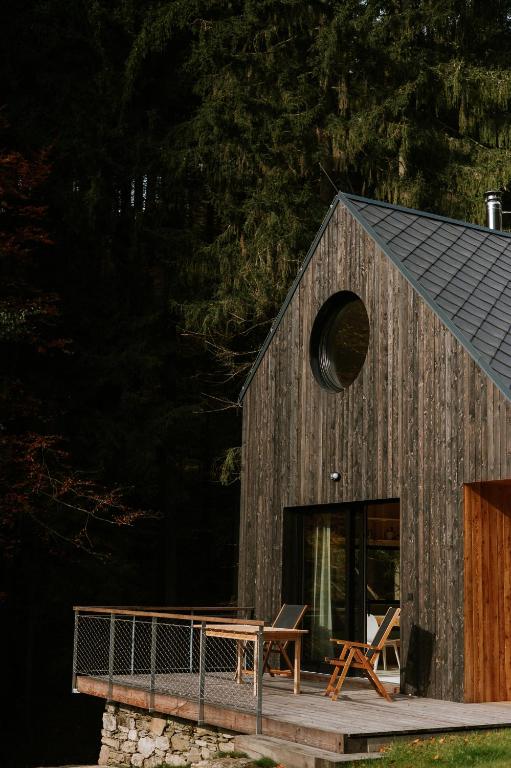a wooden cabin with two chairs on a deck at Domek Orlické hory in Deštné v Orlických horách