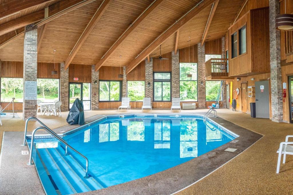 a large indoor pool in a building with wooden ceilings at Baymont by Wyndham Delaware in Delaware