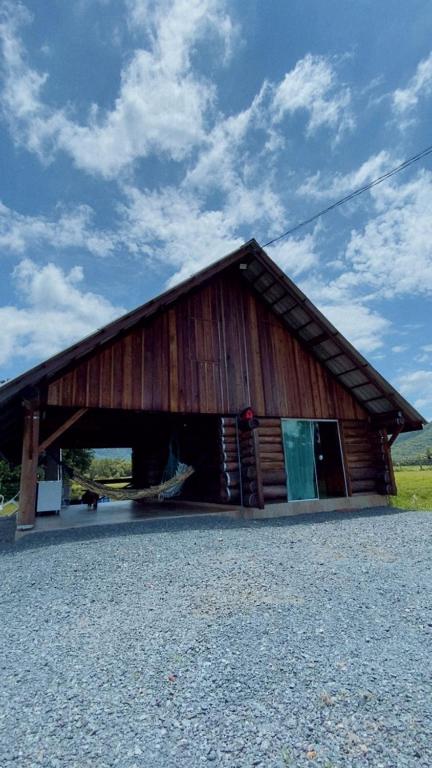 a large wooden barn with its door open at Cabana Do Lago in Joinville