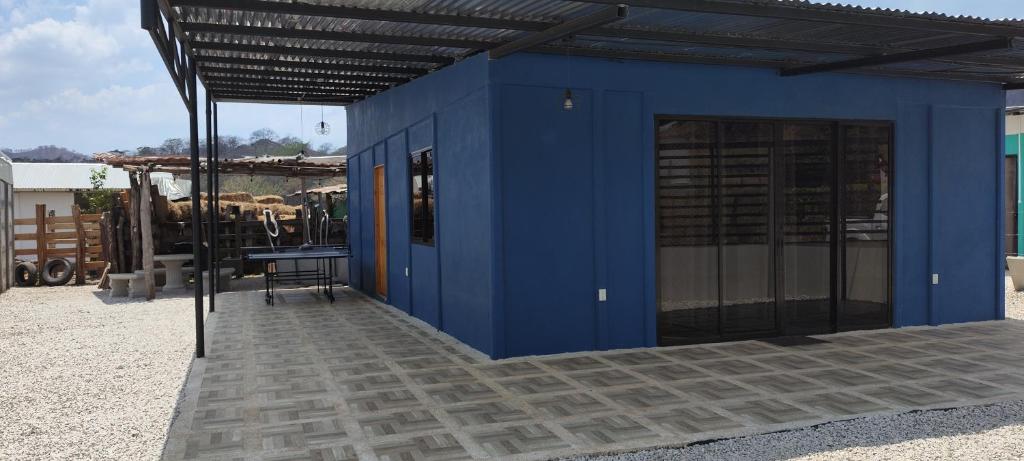 a blue building with a table and some cows at Casa Roma in Chorro