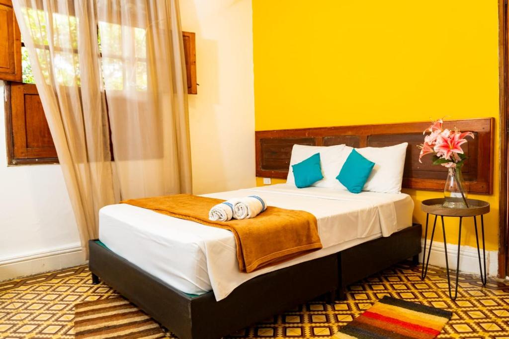 a bedroom with a bed with towels on it at Hotel Casa Real Villeta in Villeta