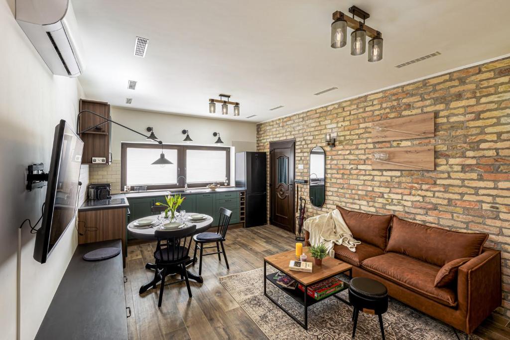 a living room and kitchen with a brick wall at Hébér Ház in Románd