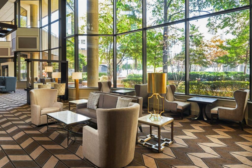 a lobby with chairs and tables and large windows at Memphis Riverline Hotel in Memphis