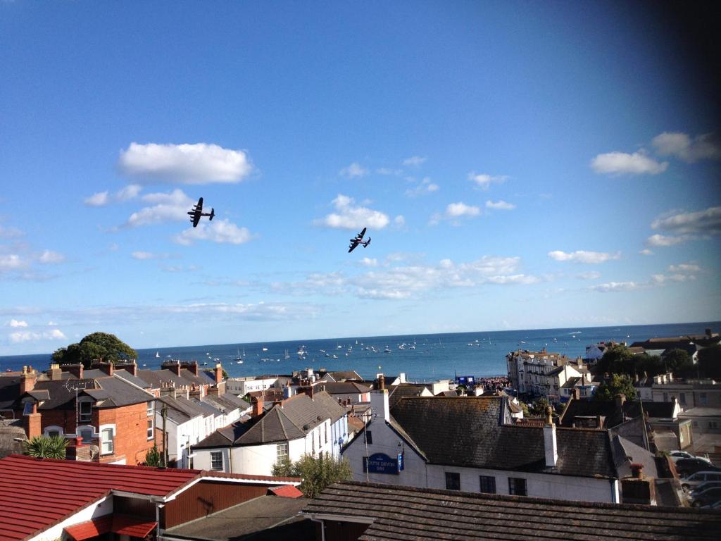 two planes flying in the sky over a city at Lammas Park House in Dawlish