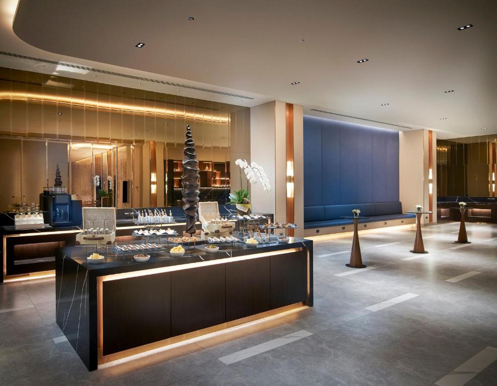 A long buffet counter sits in front of a spacious blue-accented lobby lounge.