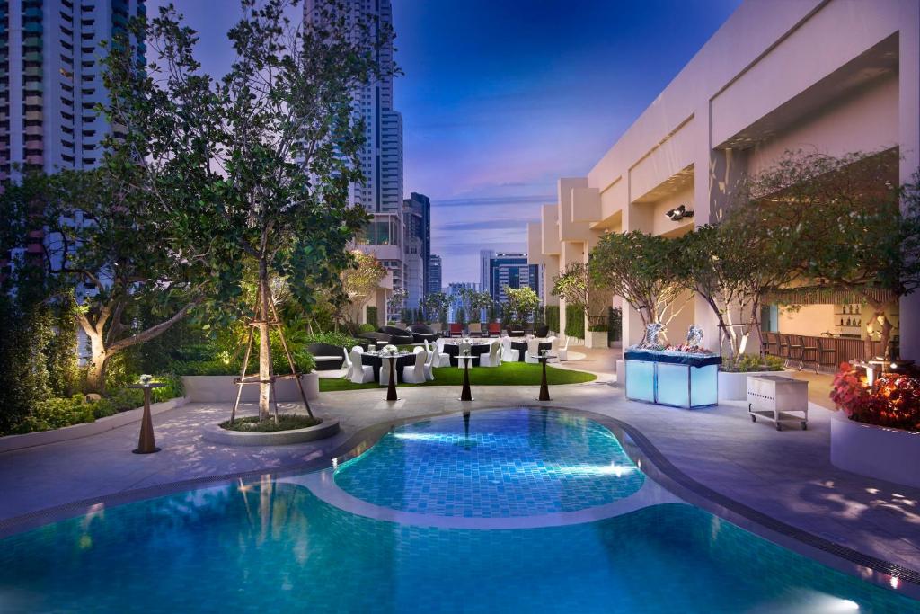 A landscaped pool terrace with a small rounded pool section and evening event setup.