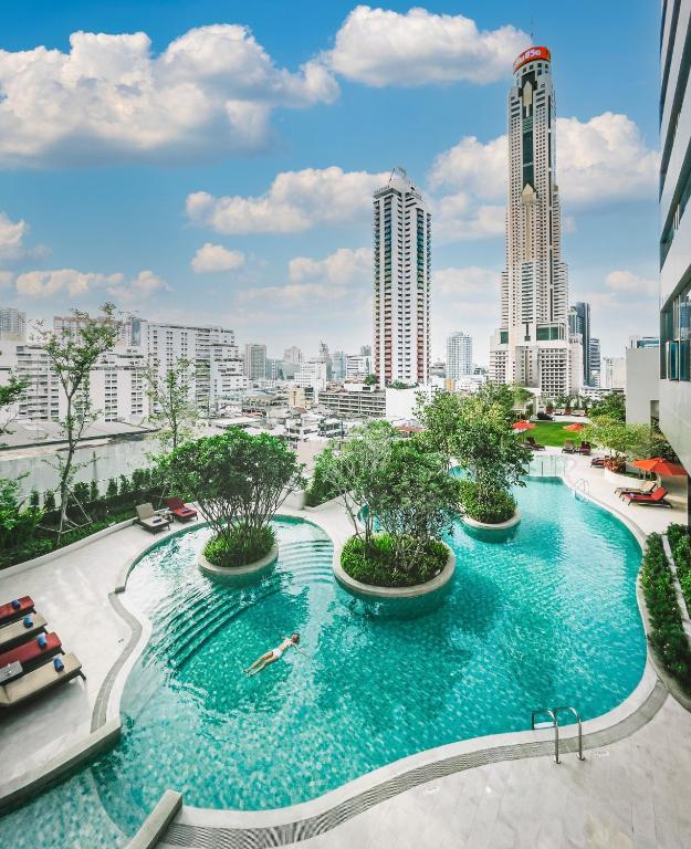 A landscaped rooftop-style pool surrounded by Bangkok high-rises.