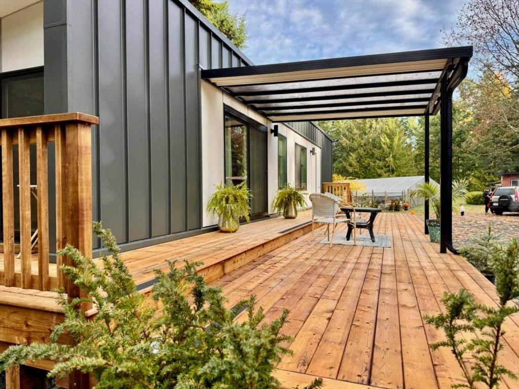 a wooden deck with a pergola next to a house at Island Coastal Retreat in Nanaimo