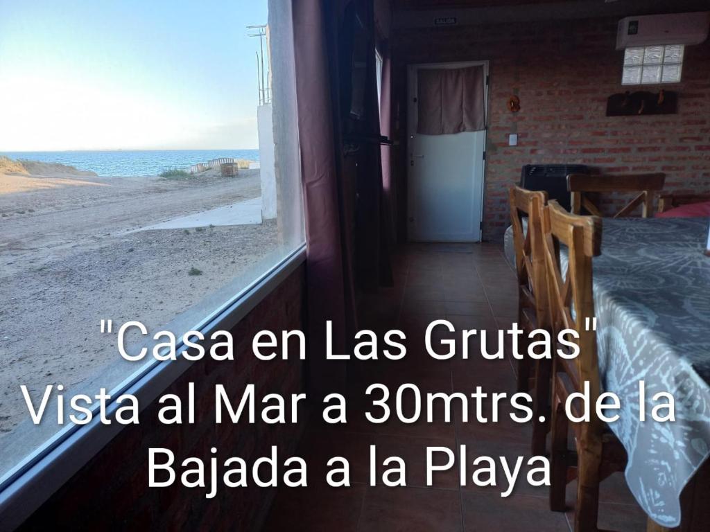 a room with a bed and a view of the beach at Casa en Las Grutas in Las Grutas