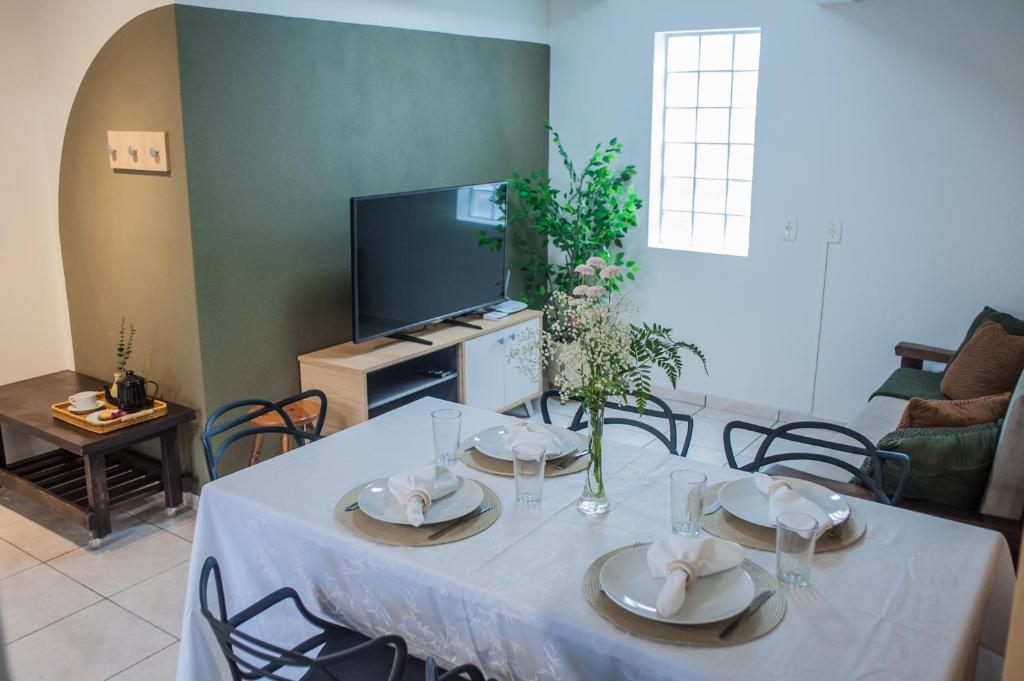 a table with plates and napkins on it in a living room at Apartamento Brisa in Veranópolis
