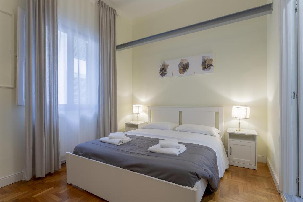 a bedroom with a large bed with two towels on it at Delux Via Faenza in Florence