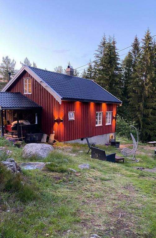 a red barn with lights on the side of it at Drangedal Cabin House in Drangedal