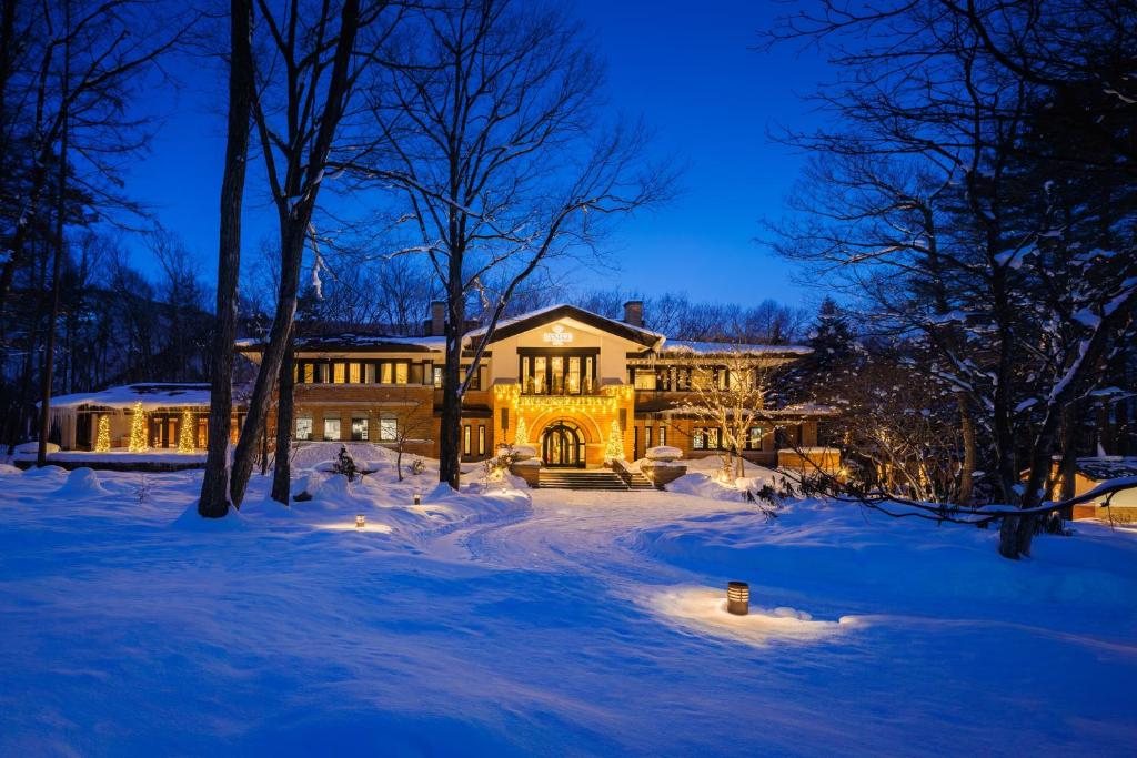 a large house in the snow at night at Hotel La Neige in Hakuba