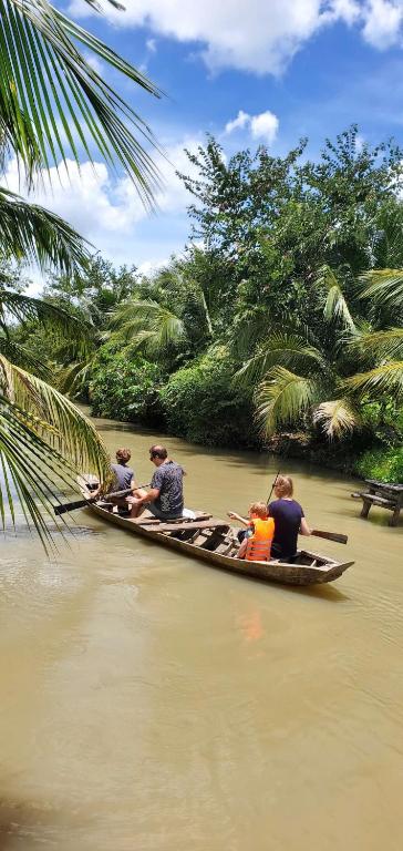 a group of people in a boat on a river at Rustic Homeaway - Stay with the local in Phong Ðiền