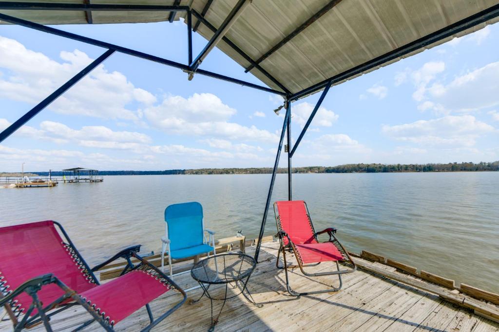 a group of chairs sitting on a dock on a lake at Lakefront w/ Dock, Detached Studio, Fire Pit! in Georgetown