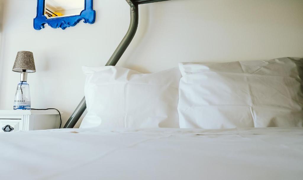 a bed with white sheets and pillows on it at Help Yourself Hostels - Restelo in Lisbon